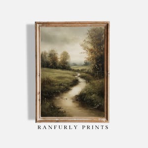 May include: A framed landscape painting shows a tranquil river meandering through a grassy field beneath a cloudy sky. The artwork uses muted greens, browns, and beiges, with trees along the riverbank. The text "RANFURLY PRINTS" is at the bottom.