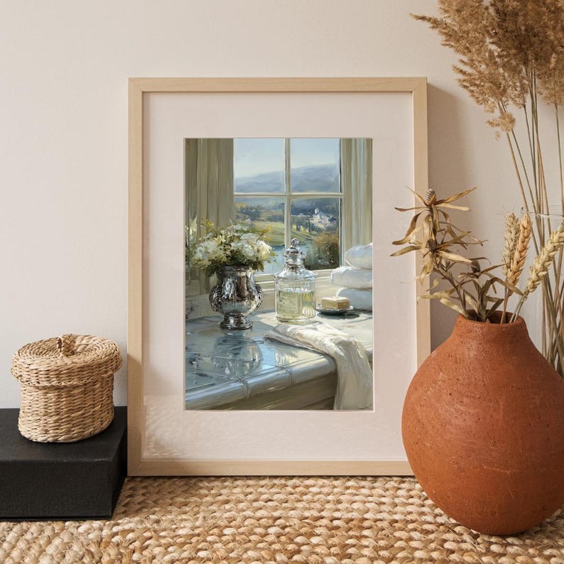 May include: A framed print of a still life scene. A silver vase with white flowers sits next to a clear glass bottle and a stack of white towels. The window in the background shows a landscape with a river and a building.