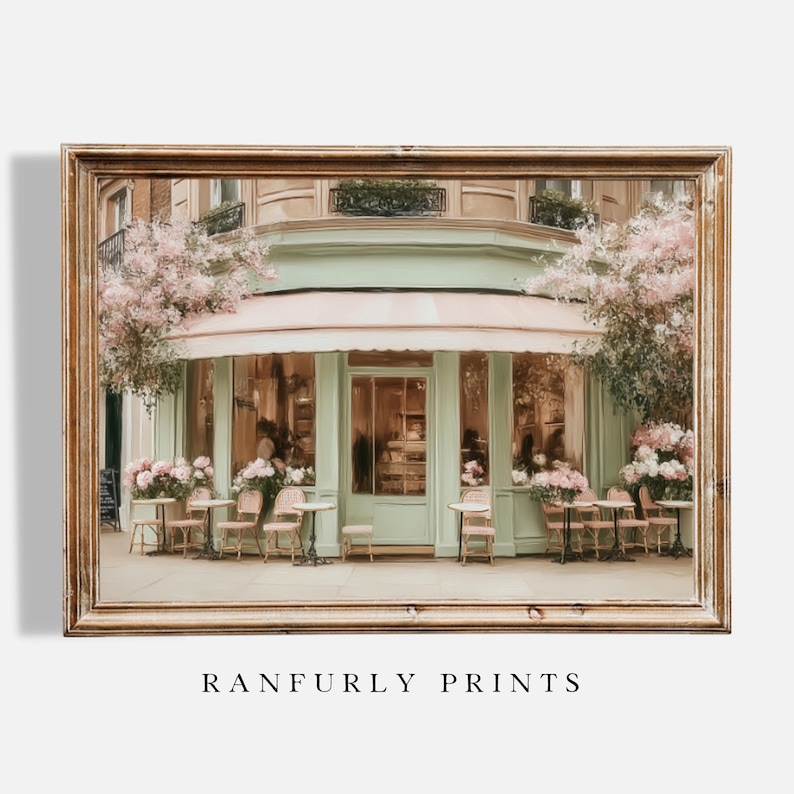 K&ouml;nnte beinhalten: Gerahmter Kunstdruck eines Pariser Caf&eacute;s mit hellgr&uuml;ner Fassade, rosa Markise und Sitzgelegenheiten im Freien. Das Bild zeigt Tische, St&uuml;hle und Blumengestecke. Der Text "RANFURLY PRINTS" befindet sich unten.