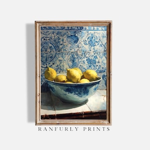 May include: A framed print featuring a still life of lemons in a blue and white bowl. The bowl sits on a white surface in front of a blue patterned tile wall. The print is labeled "RANFURLY PRINTS".