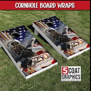 May include: Two rectangular cornhole boards featuring a graphic of a bald eagle in flight against a backdrop of the American flag. The design includes a badge with the text 250 YEARS OF FREEDOM 1776-2026. The boards have a circular hole.
