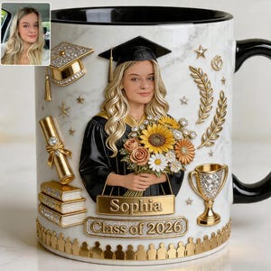 Puede incluir: Taza de graduación de cerámica blanca con un retrato de una graduada sosteniendo flores. La taza tiene detalles dorados, un asa negra y el texto "Sophia Class of 2026". Elementos decorativos: birrete, diploma, libros y un trofeo.