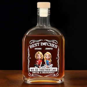 May include: A clear glass liquor bottle with a wooden stopper. The bottle is filled with a brown liquid and features a graphic with the text "BEST BITCHES" and the names "Amanda" and "Jennifer". Below the graphic is the text "WE GO TOGETHER LIKE DRUNK & DISORDERLY".
