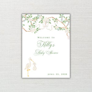 Puede incluir: Un letrero de bienvenida para baby shower con una ilustración de cigüeña. El letrero presenta el texto "Welcome to Kelly's Baby Shower" en una elegante escritura, con la fecha del 25 de abril de 2026. El diseño incluye detalles florales y cintas en verde y blanco.