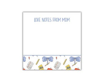 May include: A white notepad with the text "LOVE NOTES FROM MOM" in light blue. The bottom border features a repeating pattern of blue bows, pencils, pushpins, notebooks, apples, and pencil cases.