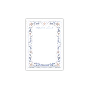 May include: A white card with a blue and peach border featuring seashells, waves, and a ribbon. The text "Stephanie Dillard" is printed in the center of the card.