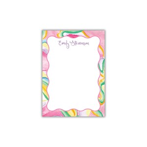 May include: Pink notepad with a colorful abstract design border. The notepad has a white writing area and the name "Emily Stevenson" at the top.