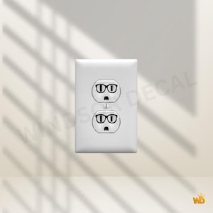 Peut inclure: Plaque de prise électrique blanche avec deux prises, chacune décorée d'un motif de lunettes à monture noire. Les prises ont une expression surprise. L'image est sur un fond neutre avec des ombres.