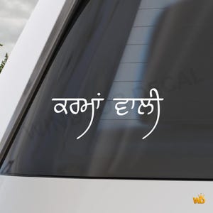 Op de afbeelding: Witte vinyl auto sticker met tekst in Punjabi-schrift. De tekst is in een vloeiende, cursieve stijl en is aangebracht op de achterruit van een witte auto. Voor voertuigdecoratie.