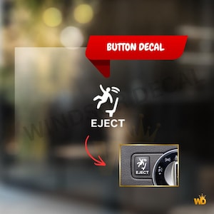 Könnte beinhalten: Ein weißer Vinyl-Knopfaufkleber mit einer Grafik einer Person, die aus einem Sitz geschleudert wird, mit dem Text EJECT darunter. Ein rotes Banner oben zeigt BUTTON DECAL, und ein Inset zeigt den Aufkleber auf einem schwarzen Armaturenbrettknopf.