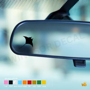 May include: A black manta ray silhouette decal applied to a car rearview mirror. Below the mirror, a color selection chart displays nine rectangular swatches in pink, black, white, ice blue, orange, red, gold, green, and yellow with labels.