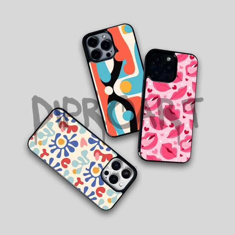 May include: Three different phone cases with colorful abstract designs. The first case has a blue, orange, and black abstract design. The second case has a pink and red design with lips. The third case has a white background with blue, red, and orange abstract shapes.