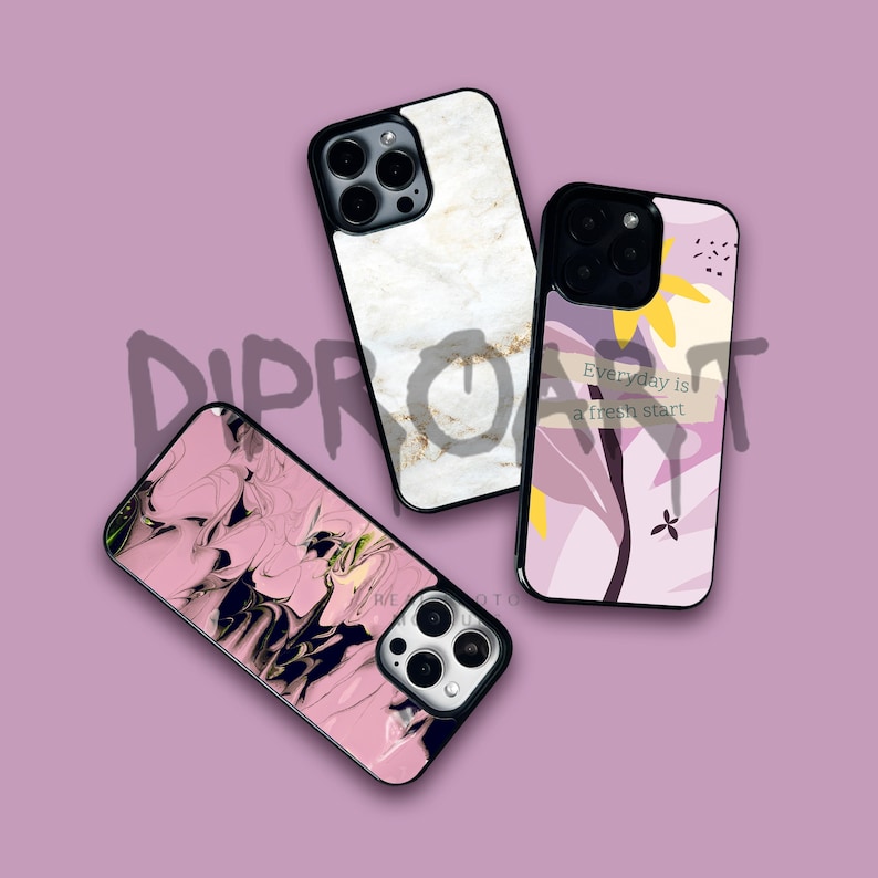 May include: Three different iPhone cases with unique designs. The first case has a white marble pattern, the second case has a pink and black abstract design, and the third case has a purple and yellow floral design with the text "Everyday is a fresh start".