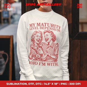 May include: White sweatshirt with a red graphic of two laughing women and the text "MY MATURITY LEVEL DEPENDS ON WHO I'M WITH." The graphic is a vintage style design. The sweatshirt is 14.5" x 18" and is a PNG image.