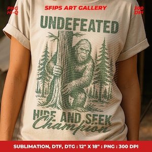 May include: Beige t-shirt featuring a green graphic of a Bigfoot holding a tree, with the text "UNDEFEATED" above and "HIDE AND SEEK CHAMPION" below. The shirt is 12" x 18" and made with sublimation, DTF, and DTG printing.