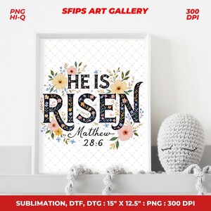 May include: A framed art print with the words "HE IS RISEN" in a floral design. The print includes the text "Matthew 28:6". The frame is white, and the print measures 15" x 12.5".