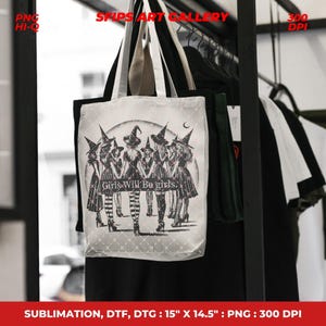 May include: White tote bag featuring a black and white illustration of seven women in witch hats, with the text "Girls Will Be Girls." The bag measures 15" x 14.5". The bag has black and white handles and is hanging on a rack with other clothing.