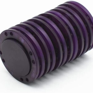May include: A cylindrical object with a series of purple rings. The object has a dark purple circular end cap with small holes around the edge. The rings are stacked closely together, creating a ribbed texture. The object is on a white background.