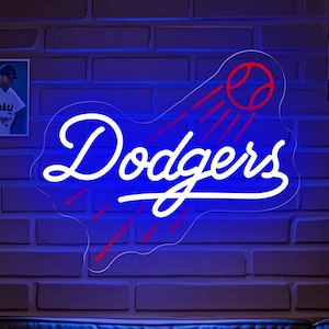 May include: A blue and red neon sign with the word "Dodgers" in white lettering. The sign is lit up and hanging on a brick wall. There are baseball pictures on the wall behind the sign.
