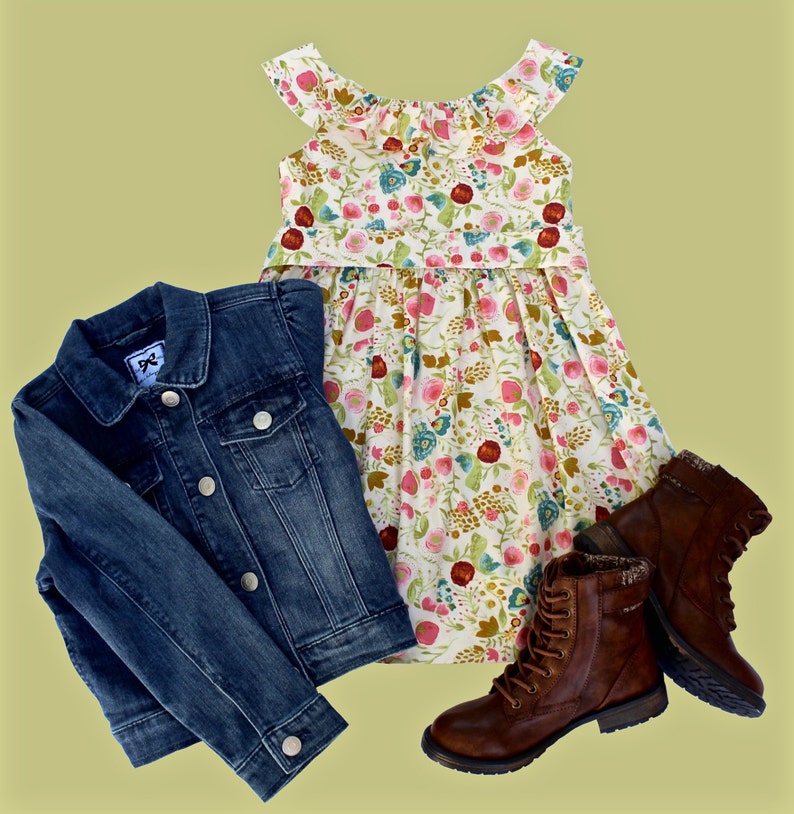 May include: A denim jacket, floral dress, and brown leather boots are displayed on a light green background. The dress has a white base with a colorful floral pattern. The boots have laces and a textured design.