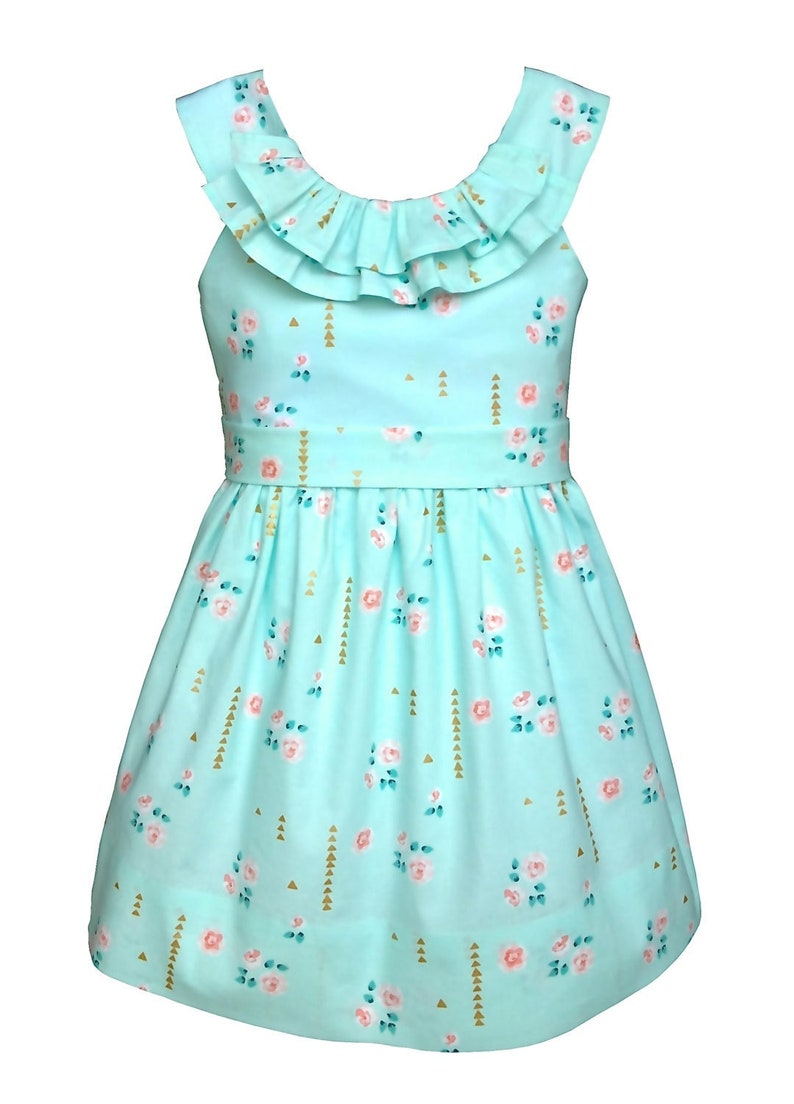 May include: A light blue dress with a floral pattern. The dress features a ruffled neckline and a fitted waist. The fabric is decorated with pink roses, gold triangles, and vertical gold lines. The dress is designed for children.