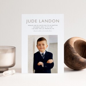 May include: A baptism invitation with a photo of a young boy in a suit. The invitation includes the boy's name, the date and time of the baptism, and the address of the church. The text reads "Jude Landon Would like to invite you to his baptism Saturday, April 2nd at 9 am 1100 Gray Fox Ln, Franklin, TN Brunch to follow at the Landon Home"