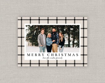 May include: A Christmas card with a black and white plaid border. A family of four is pictured in the center of the card, standing in front of a snowy background. The text "Merry Christmas" is printed in black at the bottom of the card, with the words "love, the miller family" printed below in a cursive font.