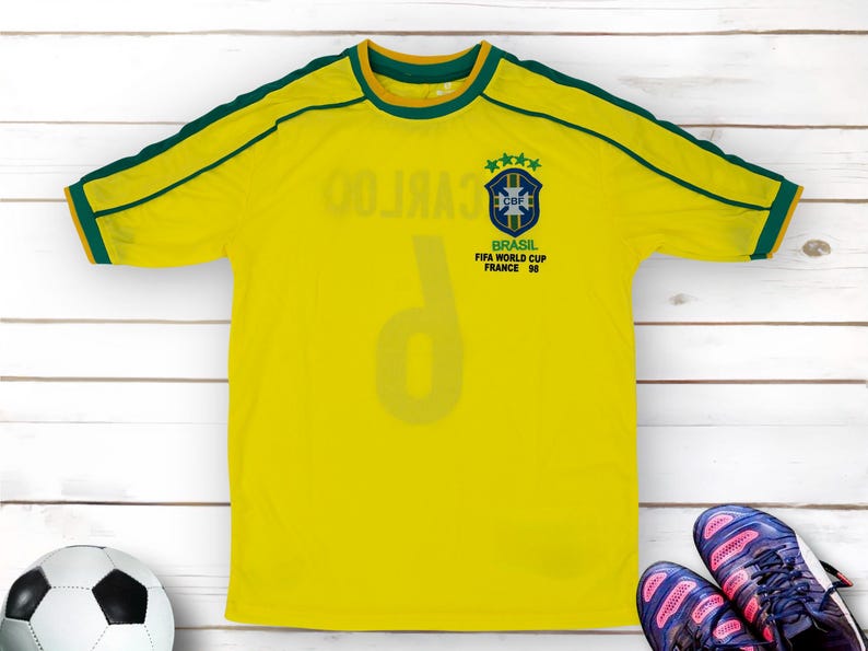 May include: Yellow football shirt with green trim and the number 9 on the front. The shirt has the Brazilian national team logo and the text "BRASIL FIFA WORLD CUP FRANCE '98".