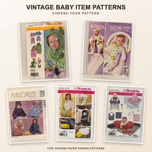 May include: Five vintage paper sewing patterns for baby items, including Simplicity 4434, Kwik Sew K3969, McCall's 2467, Simplicity 3712, and Simplicity 4225. Each envelope displays illustrations of infants wearing or using the finished sewn products.