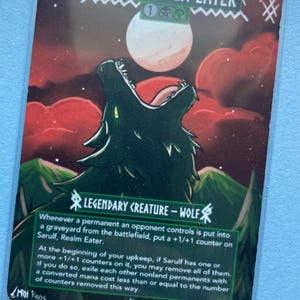 K&ouml;nnte beinhalten: Eine Sammelkarte mit einem Wolf, der einen Vollmond anheult. Die Karte tr&auml;gt den Titel "Sarulf, Realm Eater" und enth&auml;lt Spieltext. Das Kunstwerk zeigt einen dunkelgr&uuml;nen Wolf vor dem Hintergrund eines roten Himmels und gr&uuml;ner Berge.