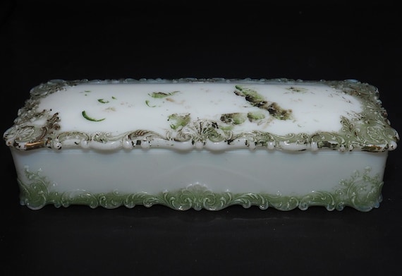 cotton gloves handling vintage milk glass display in low light cabinet