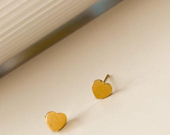 Pode incluir: Um par de brincos de coração de ouro.