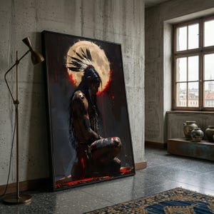 May include: A framed art print depicts a Native American figure kneeling before a large, glowing moon. The artwork features a dark color palette with red accents, and the figure is adorned with a feathered headdress. The print is leaning against a concrete wall.