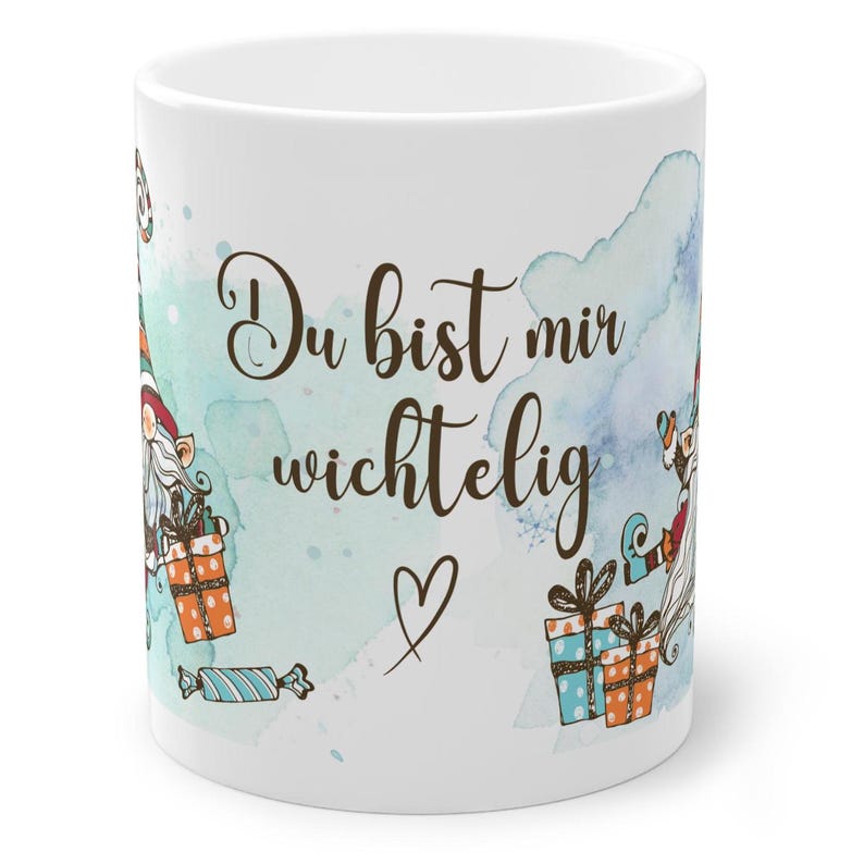 Puede incluir: Taza de cer&aacute;mica blanca con el texto en alem&aacute;n "Du bist mir wichtig" y un s&iacute;mbolo de coraz&oacute;n. La taza presenta ilustraciones de gnomos, regalos y caramelos, con aguadas de acuarela azules y turquesas.