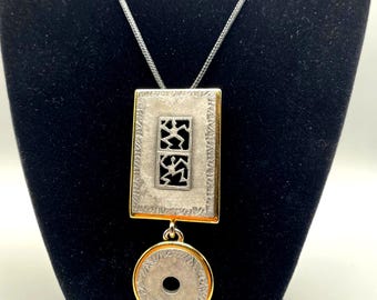 Collar con colgante geométrico grabado en metales mixtos de estilo vintage, con cordones encerados ajustables.