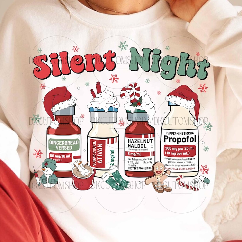 Op de afbeelding: Witte sweatshirt met de woorden "Silent Night" in rood en groen. Het ontwerp toont vier flessen met kerstthema labels, waaronder "Gingerbread Versed" en "Peppermint Mocha Propofol". Feestelijke sneeuwvlokken en vakantiegraphics maken het ontwerp compleet.