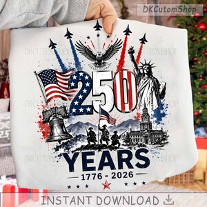 May include: A white t-shirt featuring a patriotic graphic with the text 250 YEARS 1776-2026. The design includes the Statue of Liberty, the Liberty Bell, an eagle, soldiers, American flags, and fighter jets in red, white, and blue colors.