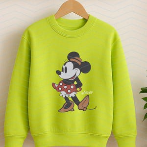 K&ouml;nnte beinhalten: Ein limettengr&uuml;nes Sweatshirt mit einer Minnie Mouse-Grafik. Minnie tr&auml;gt ihr klassisches Outfit, einen roten Polka-Dot-Rock, braune Schuhe und einen passenden Hut. Das Disney-Logo ist darunter gedruckt.