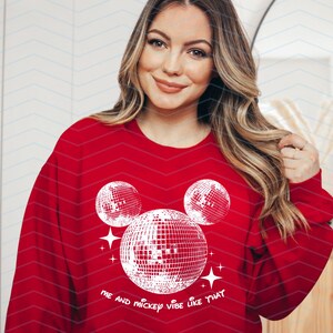 Puede incluir: Sudadera roja con un dise&ntilde;o de Mickey Mouse blanco con bolas de discoteca. El texto "Me and Mickey vibe like that" est&aacute; impreso debajo del dise&ntilde;o.