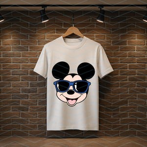 K&ouml;nnte beinhalten: Ein wei&szlig;es kurz&auml;rmeliges T-Shirt mit einem Grafikdruck des Gesichts von Mickey Mouse, der eine blau umrandete Sonnenbrille tr&auml;gt. Die Figur hat schwarze Ohren, ein helles Gesicht und einen l&auml;chelnden Ausdruck mit sichtbarer Zunge.