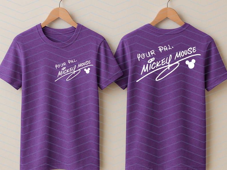 May include: A purple short-sleeved t-shirt featuring a subtle chevron pattern and white text on the front and back that reads Your Pal Mickey Mouse, accompanied by a small white Mickey Mouse head silhouette icon.