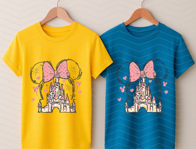 Pu&ograve; includere: Due t-shirt con un design grafico di un fiocco rosa e un castello. Il castello &egrave; rosa e bianco con una porta gialla. Il fiocco &egrave; sopra il castello. Le t-shirt sono gialla e blu.