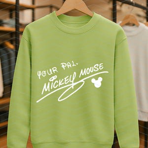 May include: A lime green crewneck sweatshirt featuring the white printed text Your Pal Mickey Mouse and a small Mickey Mouse head silhouette icon. The garment has long sleeves, a ribbed neckline, and ribbed cuffs, displayed on a wooden hanger.