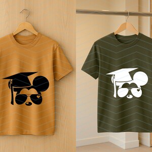 May include: Two short-sleeved t-shirts, one mustard yellow and one olive green, each featuring a graphic of a mouse wearing a graduation cap and sunglasses. The mouse design is black on the yellow shirt and white on the green shirt.