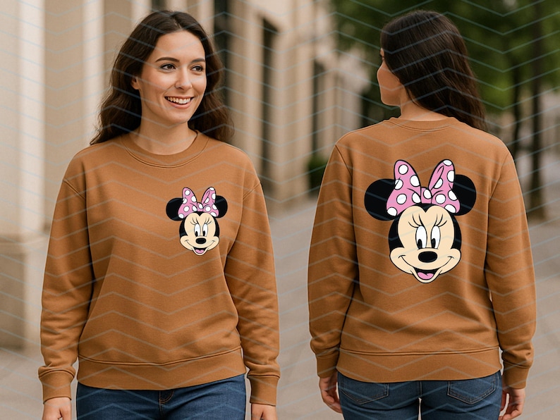 May include: A brown sweatshirt featuring a Minnie Mouse graphic on the front and back. The Minnie Mouse design includes a pink bow with white polka dots. The sweatshirt is a long-sleeved, crew neck style.