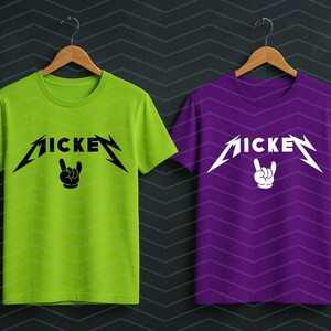 May include: Two t-shirts, one lime green and one purple, each with the word "MICKEY" in a stylized font with lightning bolt accents. Below the word is a hand gesture. The shirts are hanging on wooden hangers.
