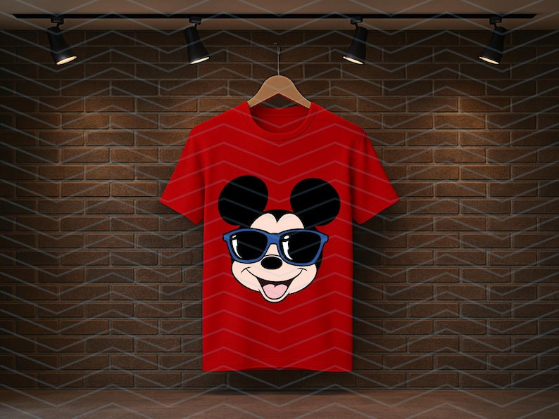 K&ouml;nnte beinhalten: Ein leuchtend rotes Kurzarm-T-Shirt mit einer mittigen Grafik der Figur Mickey Mouse, die eine dunkelblaue Sonnenbrille tr&auml;gt. Das Design der Figur umfasst gro&szlig;e schwarze Ohren, ein cremefarbenes Gesicht und einen l&auml;chelnden Mund mit Zunge.