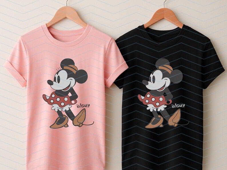 K&ouml;nnte beinhalten: Zwei T-Shirts, eines rosa und eines schwarzen, jeweils mit einem Minnie Mouse-Motiv. Die Grafik zeigt Minnie in einem roten Polka-Dot-Rock, braunen Schuhen und einem passenden Hut. Das Disney-Logo ist darunter gedruckt.