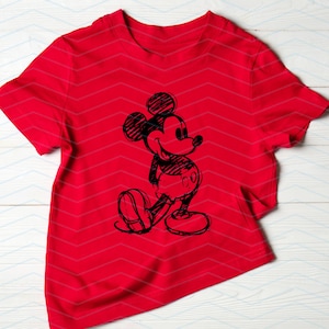 以下が含まれることがあります： 前面に白黒のミッキーマウスのスケッチが描かれた赤いTシャツ