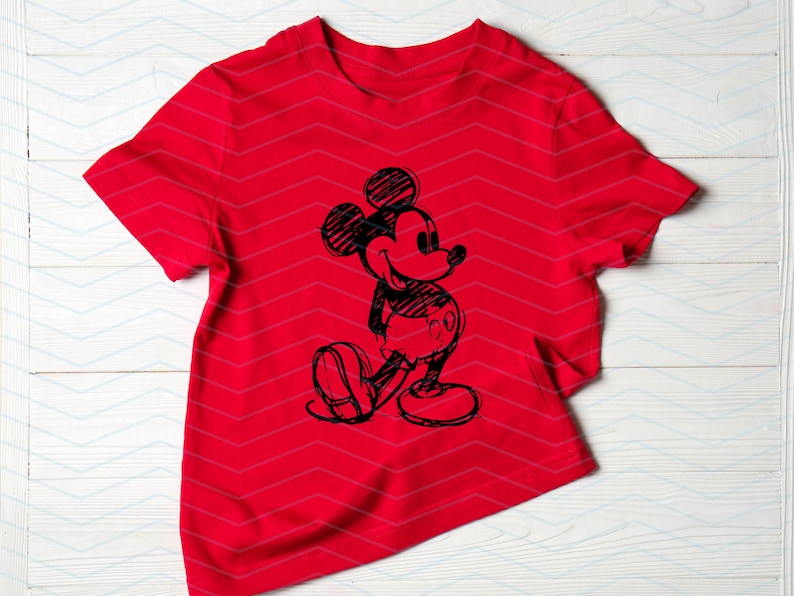 以下が含まれることがあります： 前面に白黒のミッキーマウスのスケッチが描かれた赤いTシャツ